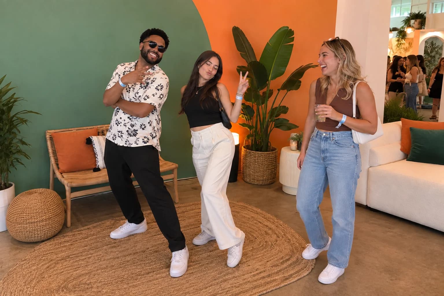 Three guests posing and laughing in a colorful sponsor lounge
