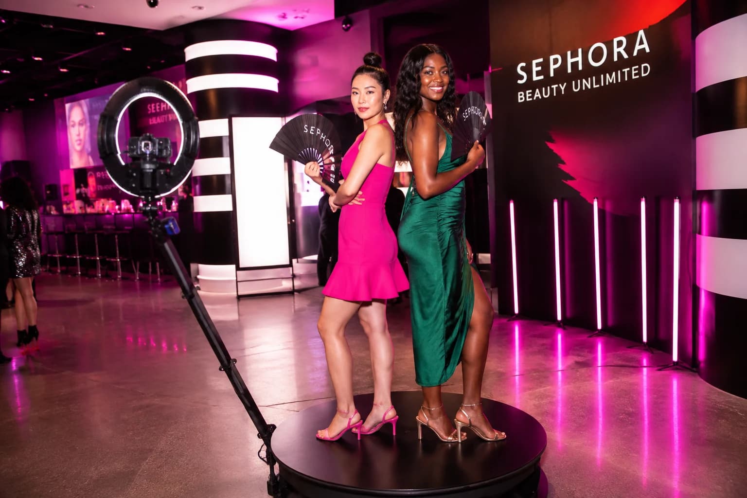 Guests moving on a circular 360 booth platform with ring and camera arm visible at a beauty activation