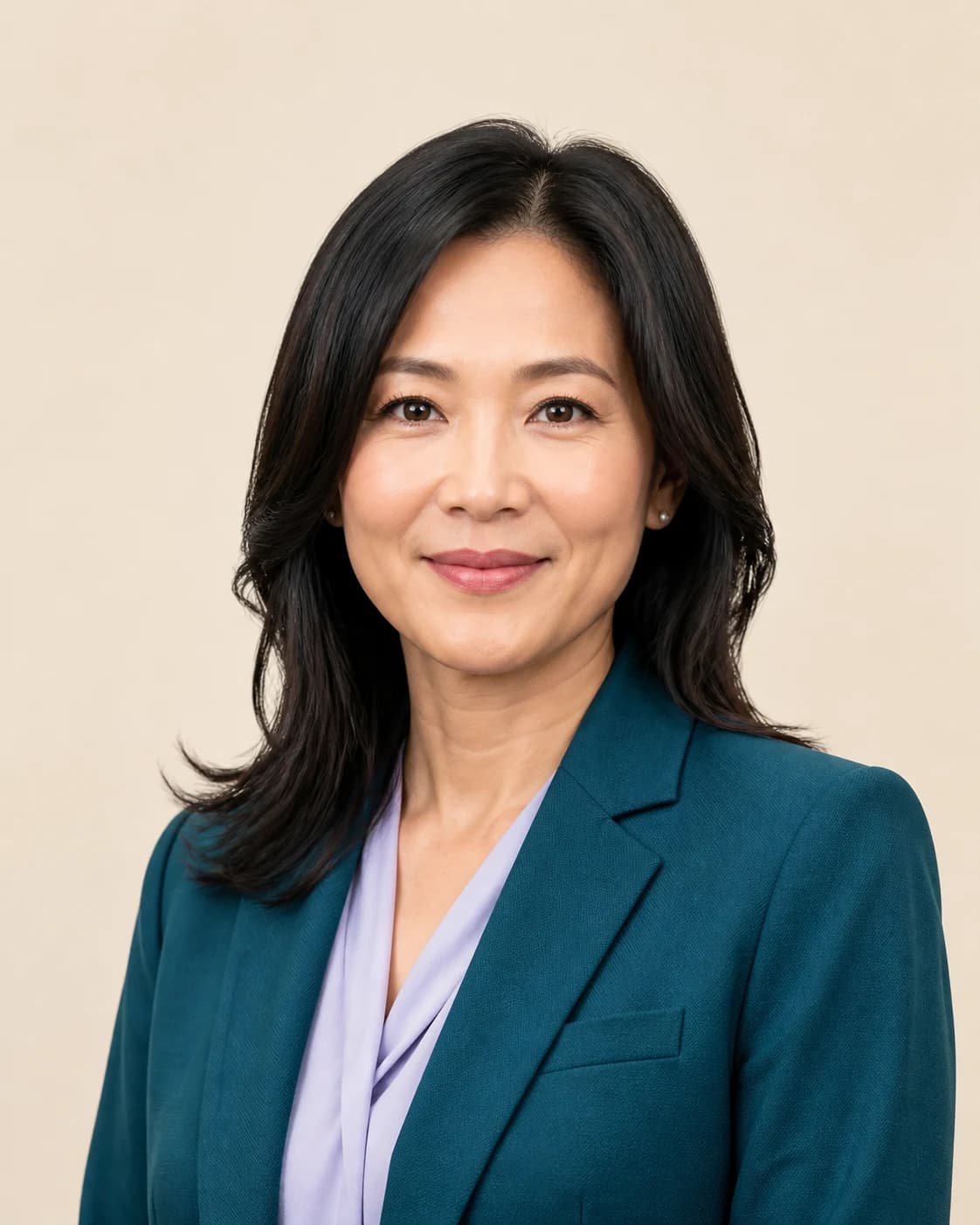 Professional headshot of a woman in a teal blazer, framed through a camera viewfinder