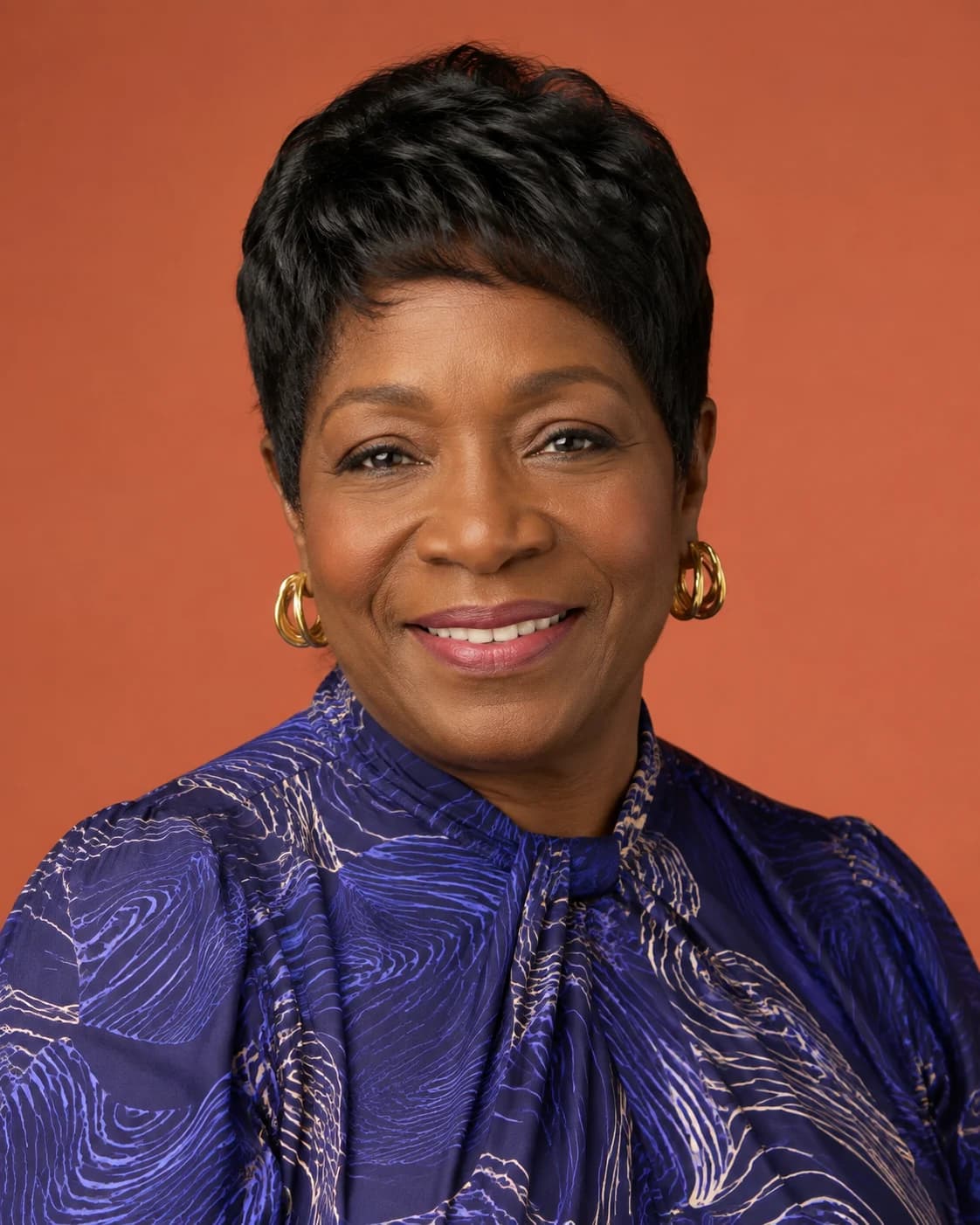 Polished event headshot of an older founder with warm editorial lighting