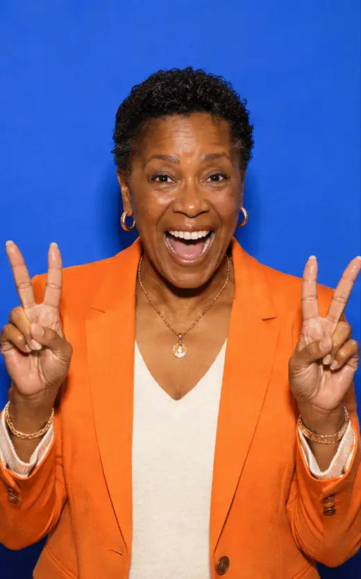 Animated GIF booth loop of a joyful Black woman in her early sixties making four expressive poses against a cobalt backdrop
